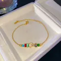 Pulsera de cadena dorada con cristales arcoíris y colgante de inicial J con pavé - Letra J