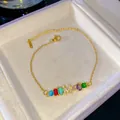 Elegante pulsera de cristales arcoíris con un colgante de letra M con brillantes oro. - M