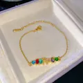 Pulsera de alfabeto arcoíris dorada con letra R de micro-pavé y piedras de color - Letra R