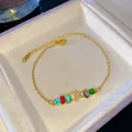 Elegante pulsera de oro con piedras arcoíris y colgante de letra T pavé para mujer. - Letra T