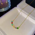Collier doré avec pierres précieuses colorées et pendentif V en cristal en boîte - Style Lettre V