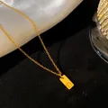 Primer plano del collar de acero de titanio dorado con colgante rectangular y letra D - Letra D / Dorado
