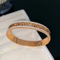 Close-up of a rose gold titanium steel bangle with Greek key pattern and crystals. - Greek Key Rhinestone Bangle / Rose Gold