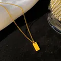 Gros plan d'un collier en acier titane doré avec un pendentif gravé de la lettre L - Lettre L / Or