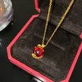 Élégant collier plaqué or avec un pendentif en forme de pomme rouge dans son écrin - Pomme de Sécurité Pierre Rouge
