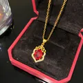 Élégant collier doré avec pendentif ovale en pierre rouge et accents de zircone - Nœud Pierre Rouge Ovale