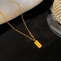 Vue macro d'un collier en acier titane doré avec un pendentif rectangulaire portant la lettre Q - Lettre Q / Or
