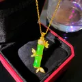 Close-up of elegant gold bamboo pendant necklace with green jade-like accent in red box - Emerald Green Bamboo (W1179-2)