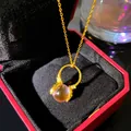 Close-up of a gold necklace with a pink bead pendant in a red luxury jewelry gift box. - Hands Holding Pink Sphere (W1194-1)