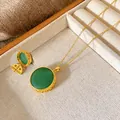 Detail view of vintage gold necklace featuring a large circular green gemstone pendant - Hollow Carved Gourd Style (W133)