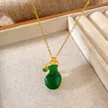 Close-up of a green gourd pendant on a gold chain necklace in a jewelry tray. - Money Bag Lucky Pouch Style (W231)