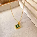 Close-up view of a gold-plated flower pendant necklace featuring radiant green zircons. - Green Zirconia Four-Leaf Clover Style (W258)