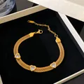 Detailed view of gold-plated mesh bracelet with three sparkling heart-shaped crystal charms. - Gold-White Zirconia Heart Mesh Bracelet