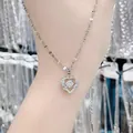 Elegante zilveren hartketting met een dansende zirconia hanger, getoond op de pols. - Hart voor Jou Halsketting (Lipketting) / Zilver