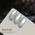 High-density silvery cat-eye magnetic nail gel polish in shade XQ19-M on nail tips. - Silver White Cat Eye (XQ19-M) / Silver