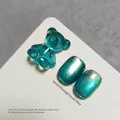 Teal gummy bear nail art charm with shimmering cat-eye nail gel swatches on a white card - Cyan (XQ112-M)