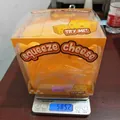 Square yellow squeeze cheese stress relief toy on a digital scale showing 585.2 grams - Large Cheese Squishy (11cm) / Yellow