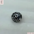 Close-up view of a retro hollow stainless steel filigree charm bead with scroll patterns - Antique Silver (Style E)