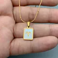 Close-up of gold Aries zodiac pendant with white shell inlay on stainless steel chain - Aries
