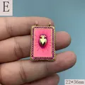 Nahaufnahme eines rechteckigen rosa Emaille-Anhängers mit Goldherz und Kristallen - Rosa 3D Herz Stil (E)