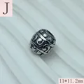 Close-up of stainless steel spacer bead with swirl and dot patterns for DIY jewelry - 11x11.2mm