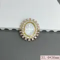 Detailed macro view of vintage oval pendant with shell relief and pink zircon halo - Pink