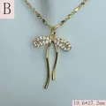 Detaillierte Nahaufnahme einer goldenen Schleifenhalskette mit funkelnden Zirkonia-Kristallen - Stil B-Vollbesetzt Weißer Zirkonia Lange Schleife