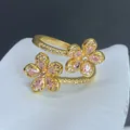 Detalle de cerca de un anillo abierto chapado en oro con dos flores de circón rosa - Estilo Abierto de Doble Flor Circonia Rosa Lágrima (F) / Dorado