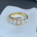 Primer plano de un elegante anillo dorado con con cinco perlas y detalles de circón - Estilo Adornado Circonia Arco de Cinco Perlas