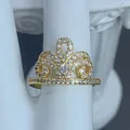 Vista dettagliata di un elegante anello a corona dorato con zirconi chiari scintillanti - Stile Corona Cava Curva (F)