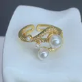 Vista detallada de un anillo ajustable dorado con perlas elegantes y circonitas brillantes - Estilo Circonia Pavé Aerodinámico de Cuatro Perlas