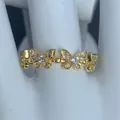 Dettaglio ravvicinato di un anello dorato con motivi a farfalla e intarsi di zirconi. - Stile Zirconia Doppia Farfalla (I)