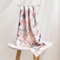 Elegant pink silk twill scarf with equestrian chain print draped on a white table - 86x86 / Plaid Equestrian Pink