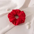 Lustrous red silk satin hair scrunchie displayed on soft white fabric with cocoon props. - L / China Red