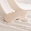 Masque de sommeil en soie de mûrier champagne élégant sur fond de soie drapée - Beige