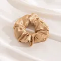 Elegant champagne gold silk scrunchie with high-gloss satin texture for hair styling - Champagne
