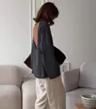 Haut en maille gris foncé à dos nu élégant présenté dans un salon au style minimaliste - S / Hauts / Gris foncé
