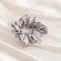 Elegant large silver grey silk hair scrunchie shown on soft pleated satin fabric - Silver Gray