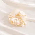 Elegant cream large silk scrunchie presented on soft champagne satin fabric background - L / Off White