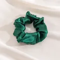 Elegant emerald green silk scrunchie placed on soft white draped satin fabric background - L / Forest Green
