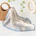 Elegante sciarpa in seta con stampa floreale blu drappeggiata su borsa in paglia rustica - Peonia / Blu nebbia