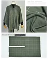 Detailed view of olive green plaid poncho featuring fabric texture and U-cut design - Striped Checkered Olive Green