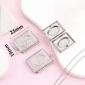 Detalle de primer plano de un relicario cuadrado de acero con medidas de 23 mm x 19 mm. - Relicario de Libro Cuadrado Árbol de la Vida (W012) / 19x23mm / Plateado