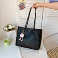 Large black vintage tote bag held by hand in a cozy room setting - With Pendant / Black