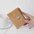 Elegant tan women's short wallet featuring crystal oval clasp and wristlet strap - Amber Brown