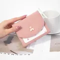 Compact pink tri-fold women's wallet featuring a cute gold bear charm and cherry print - Pink