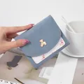 Stylish light blue and white trifold women's wallet with cute gold bear logo detail - Blue