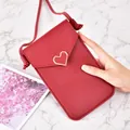 Stylish slim red crossbody phone bag for women featuring a gold heart buckle detail. - Red