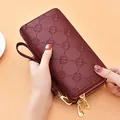 Elegant wine red embossed long wallet for women with double zippers and wrist strap - Burgundy
