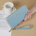 Fashionable light blue long women's wallet with wristlet strap and textured faux leather finish - Blue